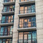 Façade d'un immeuble résidentiel moderne avec balcons vitrés, exemple de programme neuf en VEFA